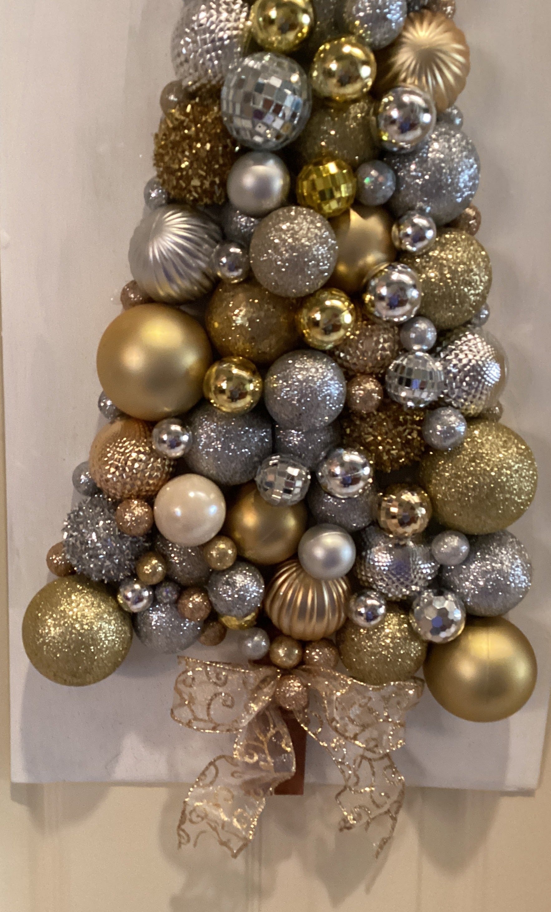 Christmas tree made from gold and silver ornaments Media 1 of 3 - close-up of lower front